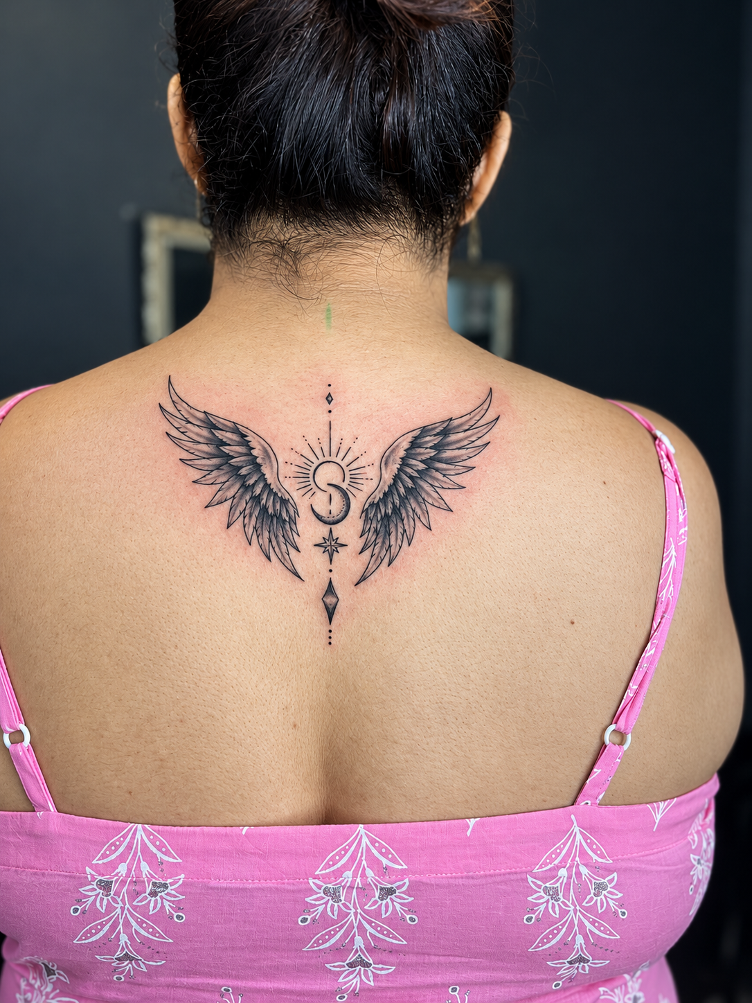 Fine line angel wings back tattoo with script initial West Delhi MJ's Tattoos